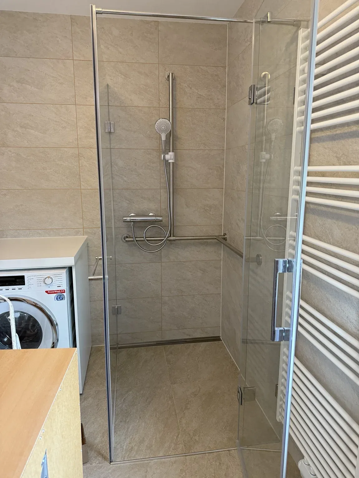 Sanitärinstallation mit moderner Dusche und Handtuchheizkörper